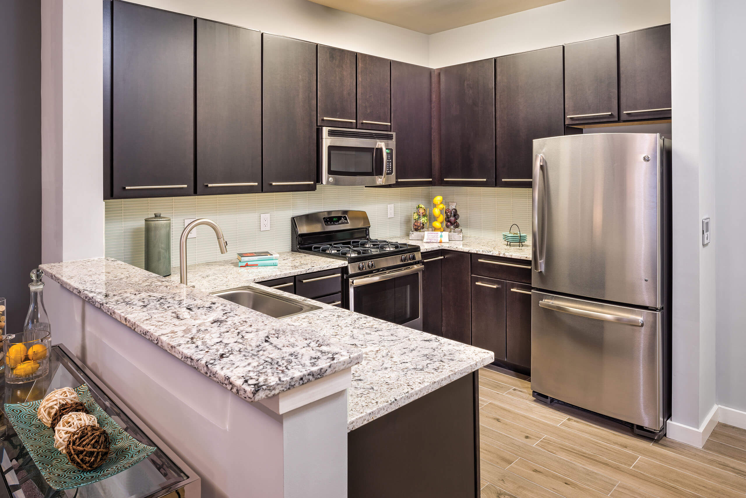 Gourmet kitchen with stainless steel appliances, dark cabinetry, and granite countertops